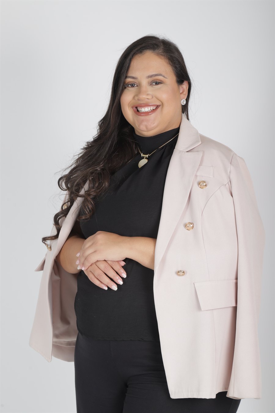 Psicóloga Flávia Santos sorrindo, de blazer rosé